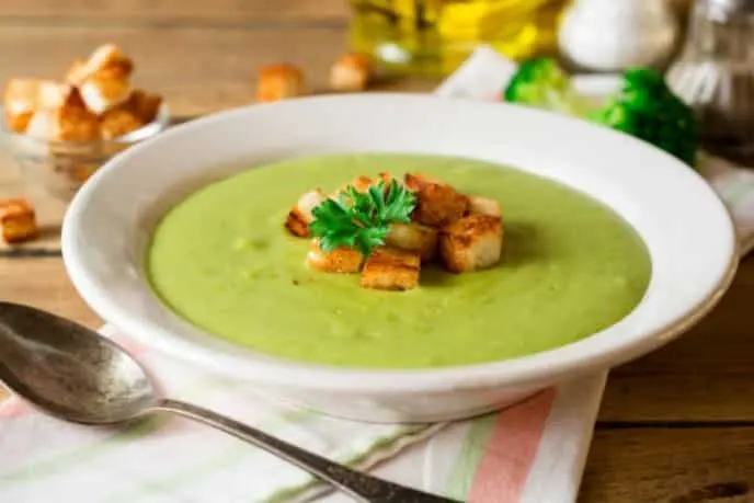 Crema de espinaca servida en un plato hondo con picatostes por encima
