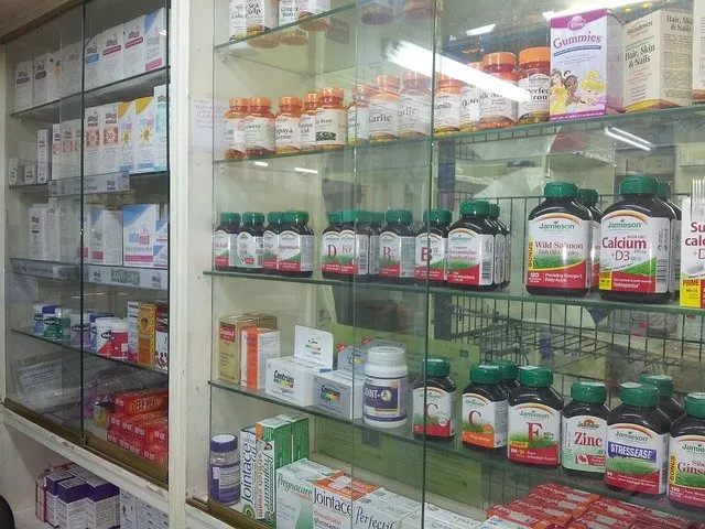 Vitrina de una tienda con estantes llenos de botes de suplementos y vitaminas