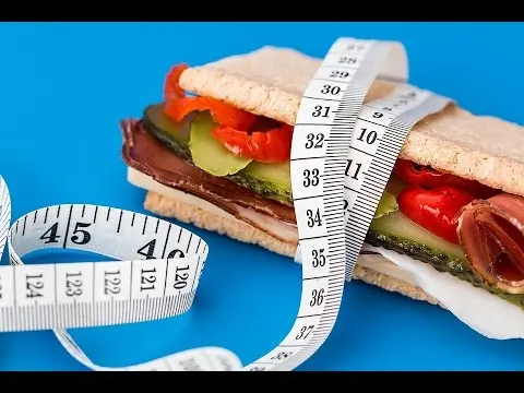 Sándwich vegetal envuelto por una cinta métrica sobre fondo azul