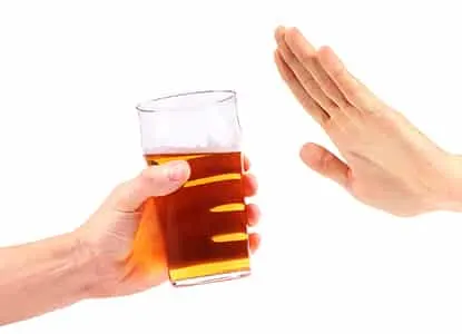 Mano que rechaza con la palma abierta un vaso de cerveza