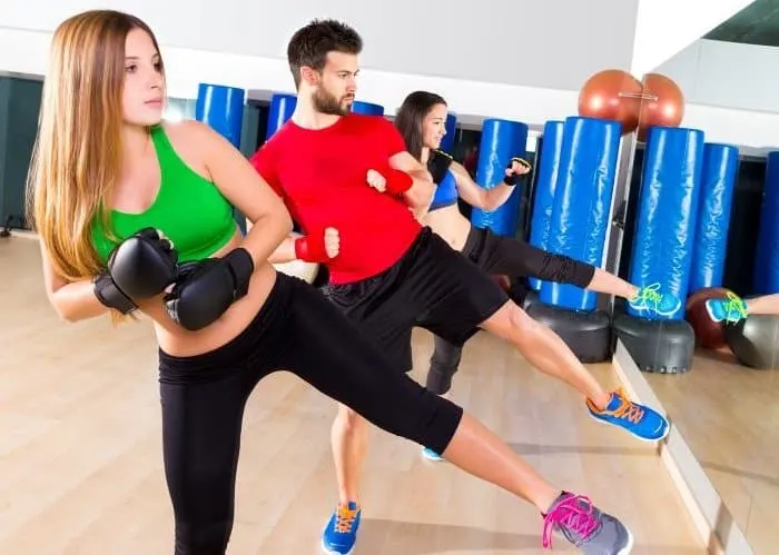 Pareja entrenando con guantes y mancuernas en una sala de gimnasio