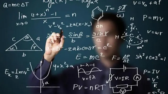 Pizarra cubierta de fórmulas matemáticas y físicas frente a una persona que escribe