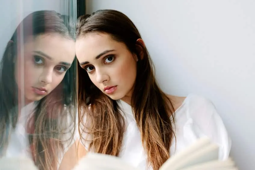Mujer joven observando su propio reflejo en un espejo