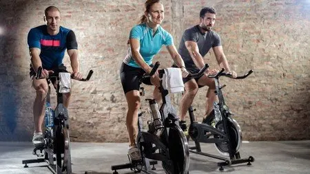 Grupo de personas pedaleando en bicicletas de spinning en un gimnasio