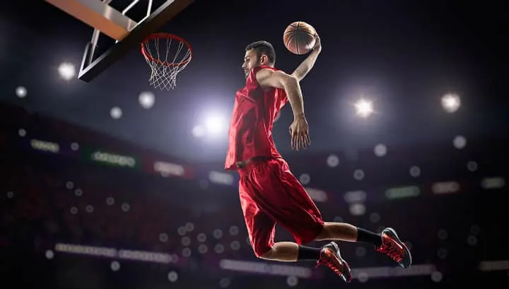 Jugador de baloncesto saltando para hacer un mate en la canasta