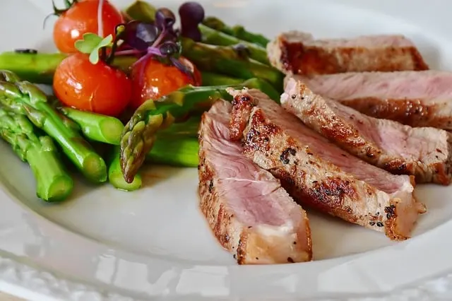 Plato de carne a la plancha con espárragos y tomates cherry
