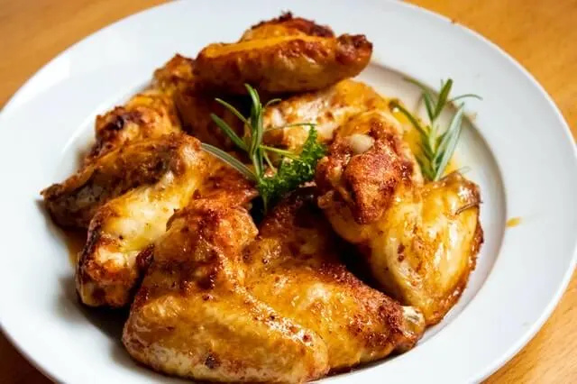 Alitas de pollo doradas al horno con romero en un plato blanco