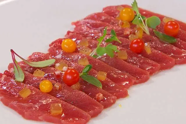 Carpaccio de atún fresco con dados de tomate amarillo y brotes