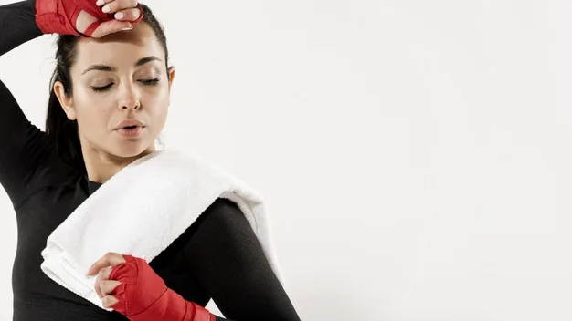 Mujer con las manos vendadas para boxear y una toalla al hombro