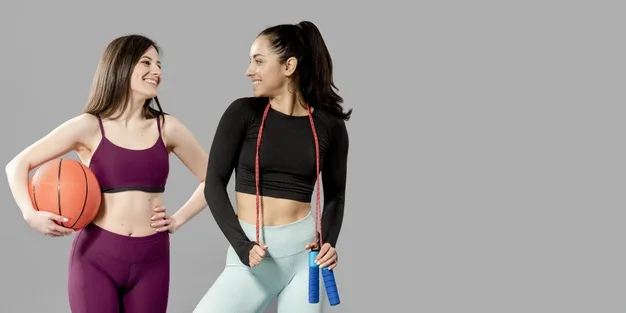 Dos mujeres con ropa deportiva, una con un balón de baloncesto y otra con una cuerda de saltar