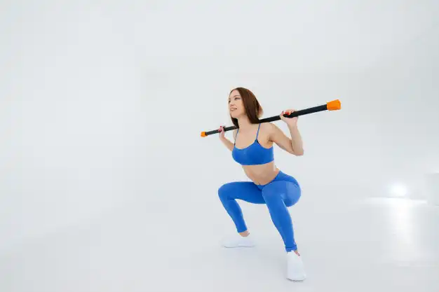 Mujer haciendo una sentadilla con una barra apoyada en los hombros