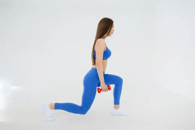 Mujer haciendo una zancada hacia delante con mancuernas en las manos